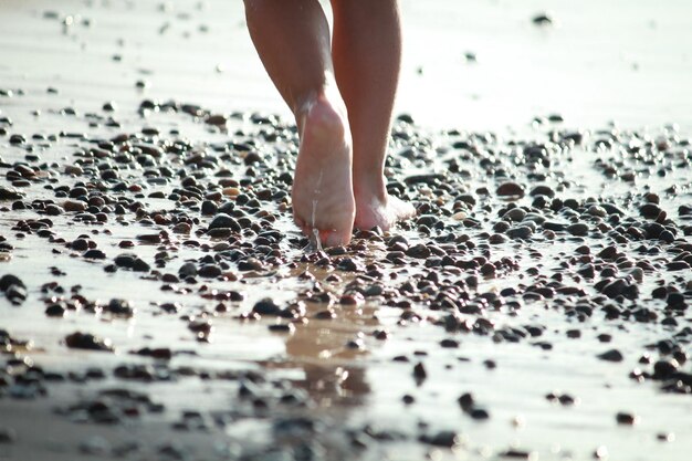 Laag gedeelte van een vrouw die op het strand loopt