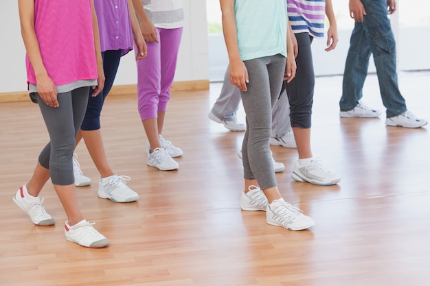 Foto laag gedeelte van fitnessles en instructeur