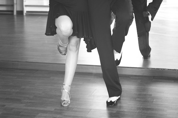 Foto laag gedeelte van man en vrouw die op een hardhouten vloer dansen