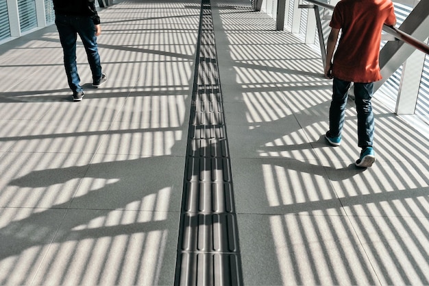 Laag gedeelte van mannen die op de voetgangersbrug in de stad lopen