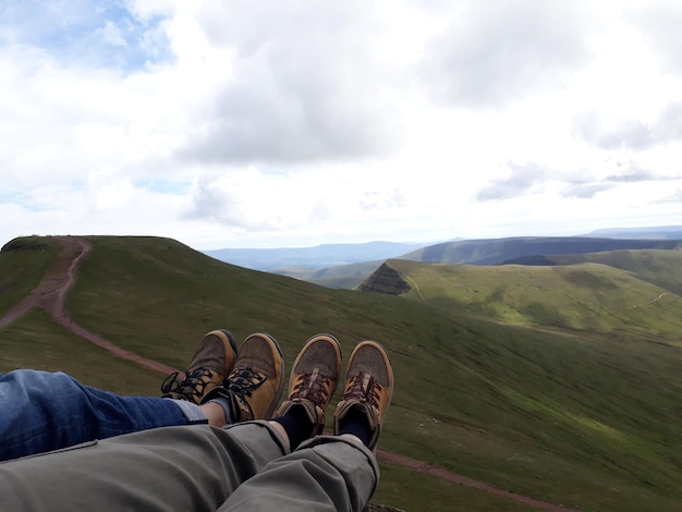 Laag gedeelte van twee mensen tegen uitzicht op pen y fan berg wales