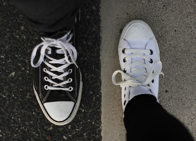 Laag gedeelte van vrienden die canvas schoenen dragen op de weg