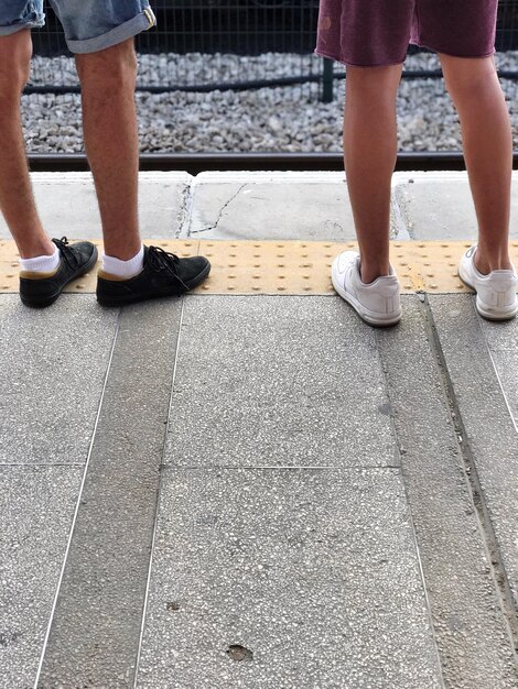 Foto laag gedeelte van vrienden op het perron van het treinstation