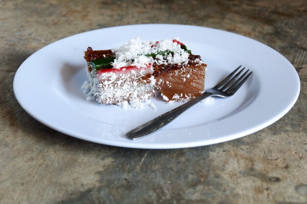 Laagcake en geraspte kokosnoot op bord met bestek, Maleis eten