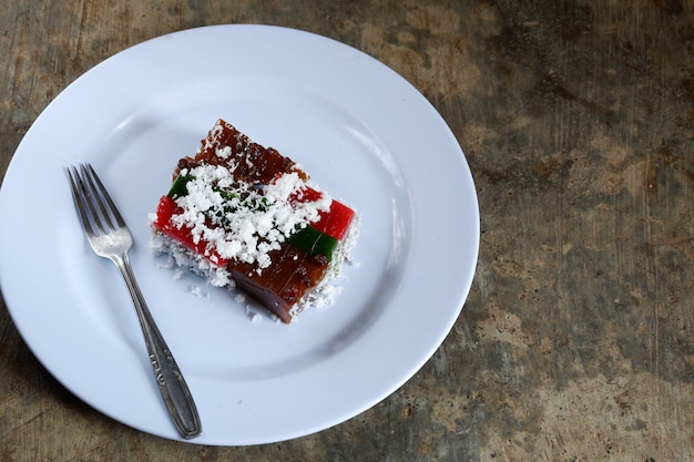 Laagcake en geraspte kokosnoot op bord met bestek, Maleis eten