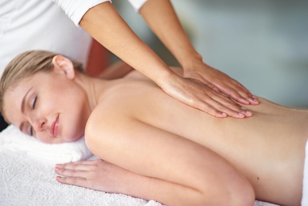 Laat al je spanning wegsmelten Shot van een jonge vrouw die geniet van een massage in de spa