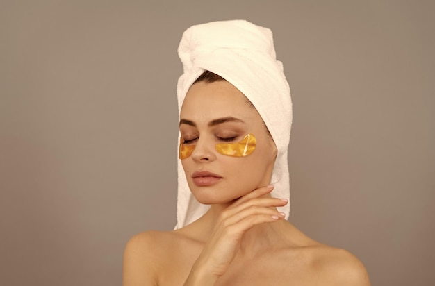 Laat de huid ademen hydraterende huid cosmetologie jonge vrouw in badstof handdoek gebruik patch
