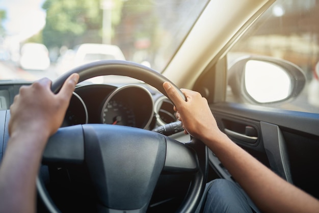 Laat de reis beginnen Bijgesneden opname van de handen van een man op de 10 en 2 positie op een stuur van een auto