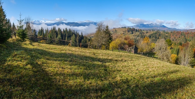 Laat in de herfst bergochtendscène met besneeuwde toppen in verre en mistige wolken in valleien Pittoreske reizende seizoensgebonden natuur en plattelandsschoonheidsconceptscène Karpaten, Oekraïne