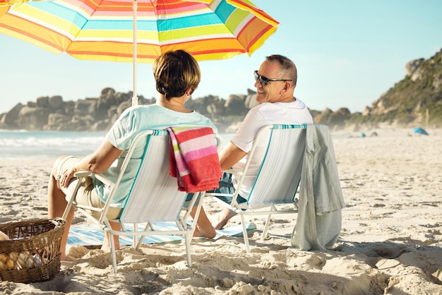 Laat je zorgen achter je en ga naar het strand Shot van een stel zittend op hun stoelen terwijl ze genieten van een dagje strand