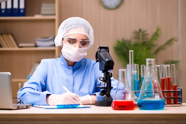 Lab chemist working with microscope and tubes