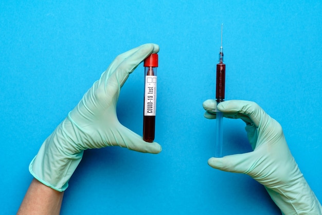 Lab technician wearing rubber gloves holding an ampoule with medicine