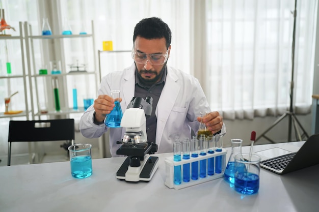 Lab worker using magnifying glass on microscope