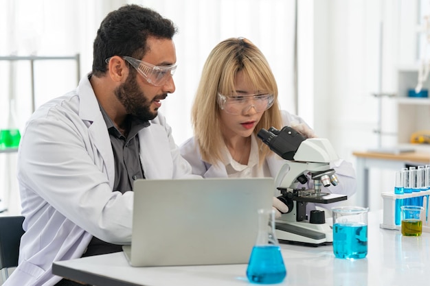 Lab worker using magnifying glass on microscope