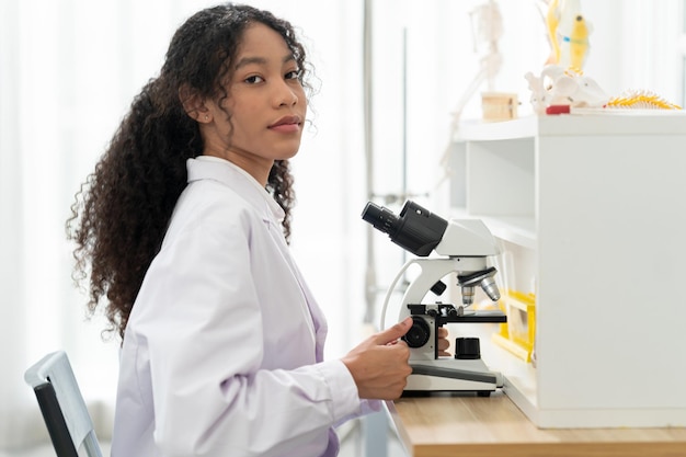 Lab worker using magnifying glass on microscope