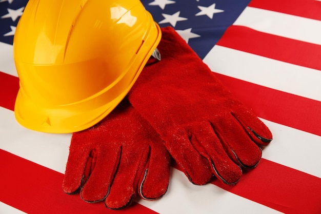 Labor day concept yellow helmet and gloves on usa national flag background