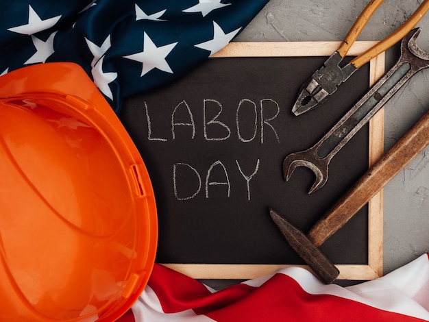 Photo labor day. hand tools and the flag of the united states of america lying on the table. view from above, close-up. congratulations to family, relatives, friends and colleagues. national holiday concept