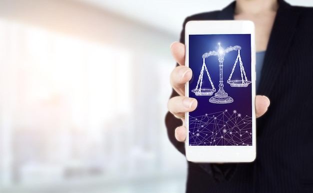 Labor Law Lawyer Legal Business. Hand hold white smartphone with digital hologram Labor Law sign on light blurred background. Libra Scales Attorney at Law Business Legal Lawyer Internet Technology.