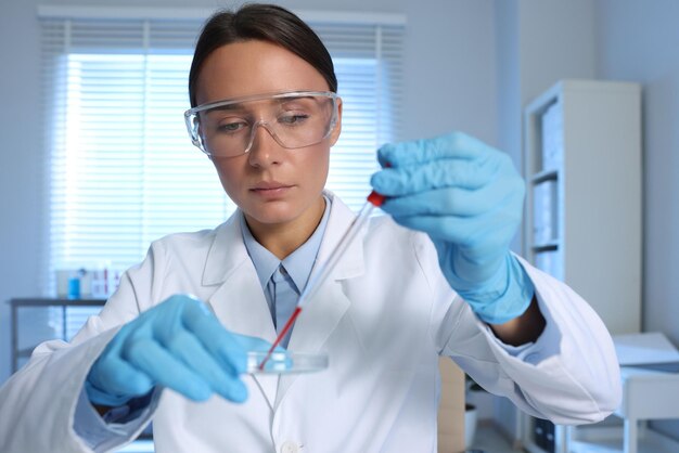 Laboratoriumonderzoek Dokter druppelt bloedmonster in een petri schotel binnen