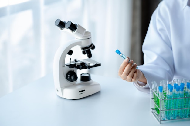 A laboratory assistant a medical scientist a chemistry researcher holds a test tube of chemicals and examines the disease from a patient's blood sample Medicine and research concept