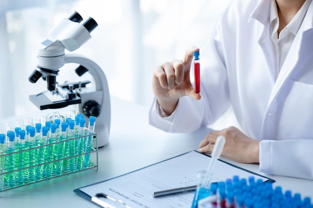 A laboratory assistant a medical scientist a chemistry researcher holds a test tube of chemicals and examines the disease from a patient's blood sample Medicine and research concept