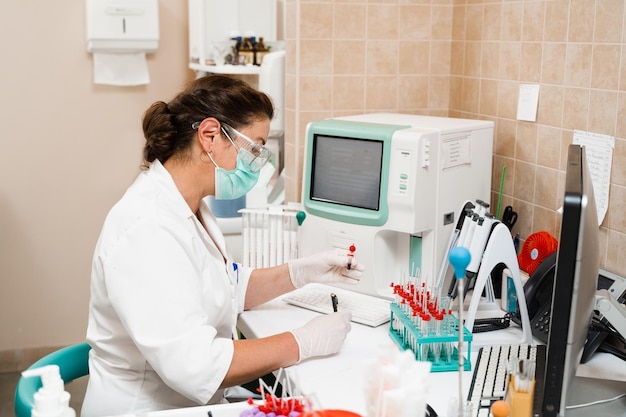 Laboratory assistant works on blood analyzer and makes hematological analysis in the laboratory Medical equipment in the lab Biochemical and hematological analysis of blood