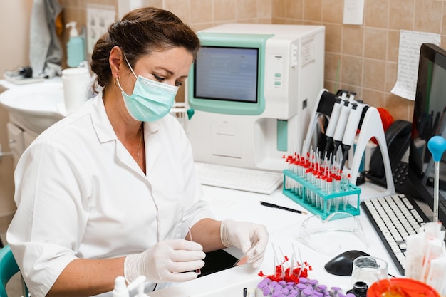 Laboratory assistant works on blood analyzer and makes hematological analysis in the laboratory Medical equipment in the lab Biochemical and hematological analysis of blood