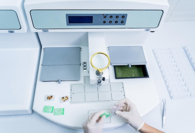 Laboratory assistant works at paraffin wax dispenser tissue embedding machine.