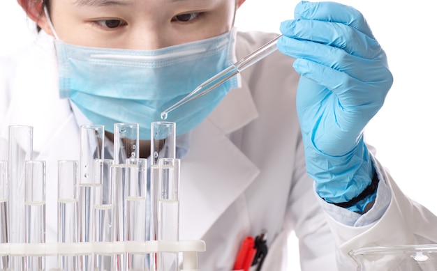 Laboratory beaker in analyst's hand in plastic glove