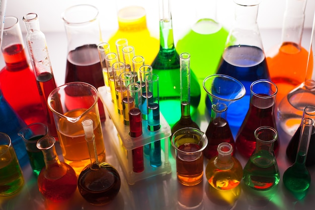 Foto vetro da laboratorio con liquidi color arcobaleno, natura morta chimica