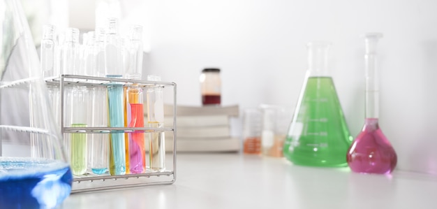 Laboratory glassware containing colour liquids putting on table.