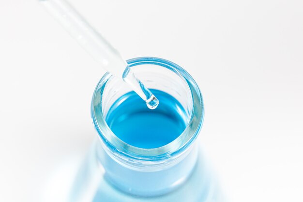 Laboratory glassware with a dropper dripping liquid into a test tube