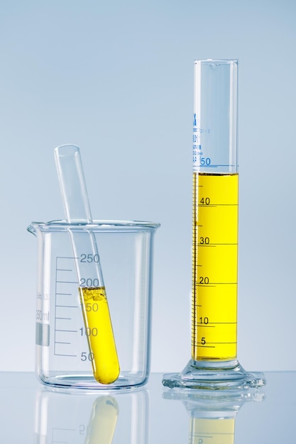 Концепция лабораторных исследований Научная лабораторная посуда с желтой жидкостью