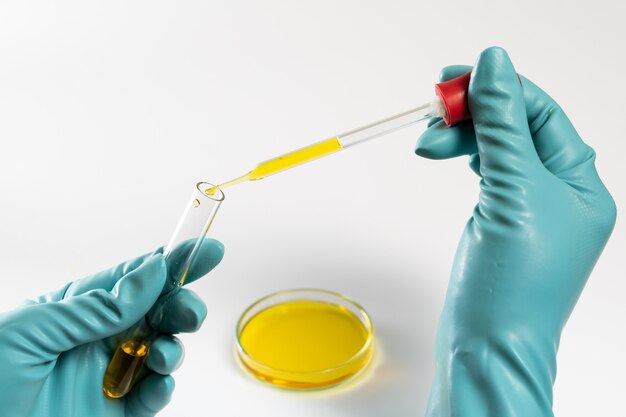 Laboratory testing lab dropper with yellow fluid test in petri dish