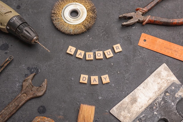 Photo labour day background concept different construction tools on dark stone background