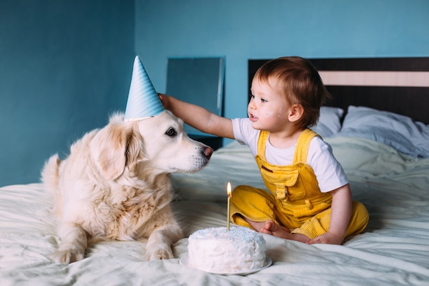 小さなかわいい子供と一緒にラブラドールゴールデンレトリバーは誕生日を祝います