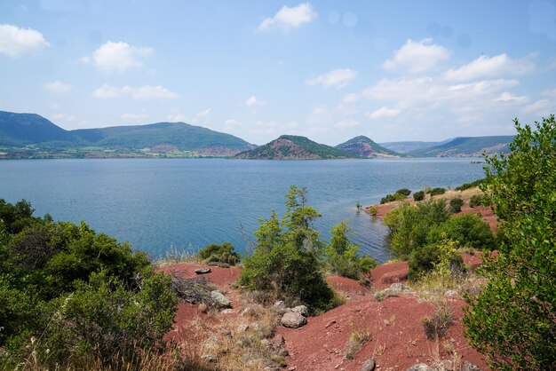 Lac du Salagou вода спокойные сумерки красный пейзаж побережье озера с панорамой на горный остров