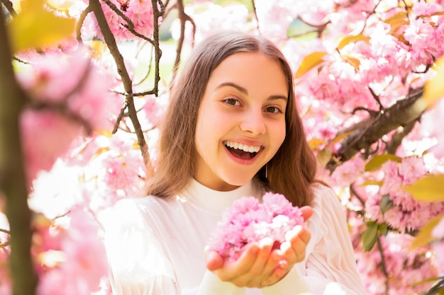 Lachend kind bij sakura-bloembloei in het voorjaar