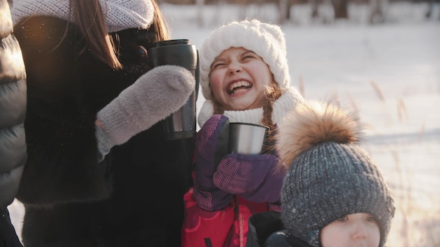 Lachend meisje dat buiten warme dranken drinkt