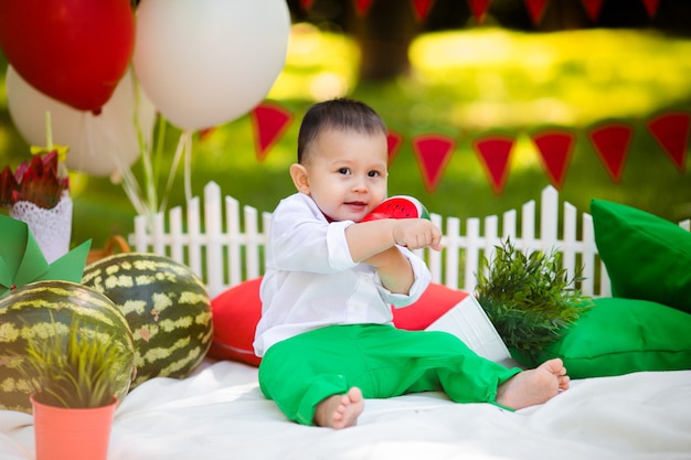 Lachende babyjongen 1-2 éénjarigen die in openlucht watermeloen eten. Zomerfeest concept