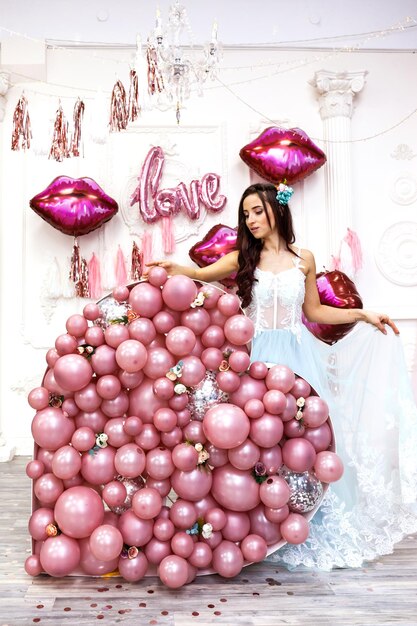 Lachende blij verrast vrouw in tule jurk met roze ballons lippen ballon roze hart achtergrond womens day