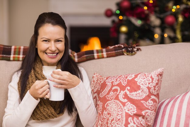 Lachende brunette genieten van warme chocolademelk