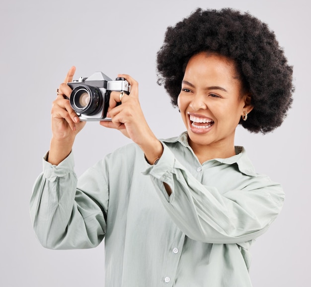 Lachende camera fotograaf en zwarte vrouw in studio geïsoleerd op een witte achtergrond fotografie professionele en grappige persoon of vrouw klaar om te beginnen met filmen, fotoshoot of het maken van foto's