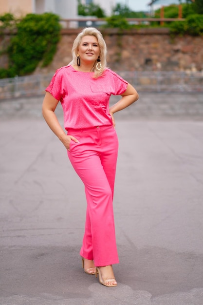 Lachende dame in roze kleding buitenshuis