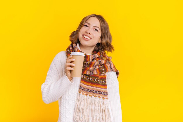 Lachende dame met kopje afhaalkoffie op kleurrijke achtergrond