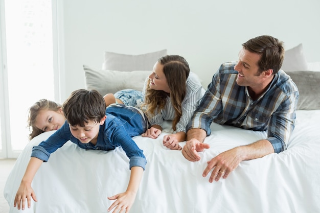 Lachende familie spelen op bed in de slaapkamer