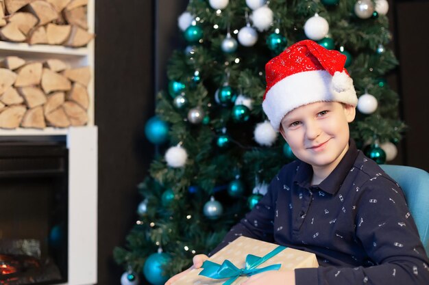 Lachende gelukkige jongen met een kerstcadeau Kerstvakantie en evenementen