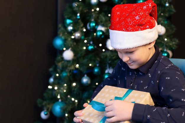 Lachende gelukkige jongen met een kerstcadeau Kerstvakantie en evenementen