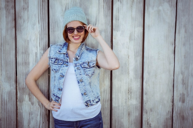 Lachende hipster vrouw in zonnebril en een muts