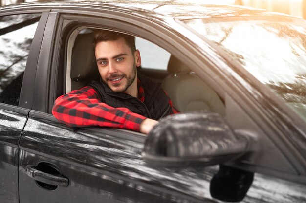 Lachende jonge blanke man. Autobestuurder